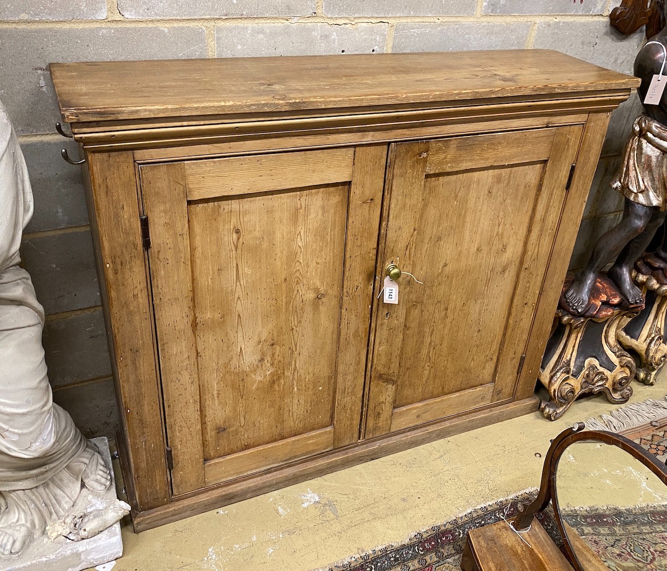 A Victorian pine two door side cabinet, with twin panelled doors, width 128cm, depth 34cm, height 106cm